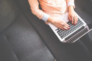 Hands typing on a laptop keyboard.