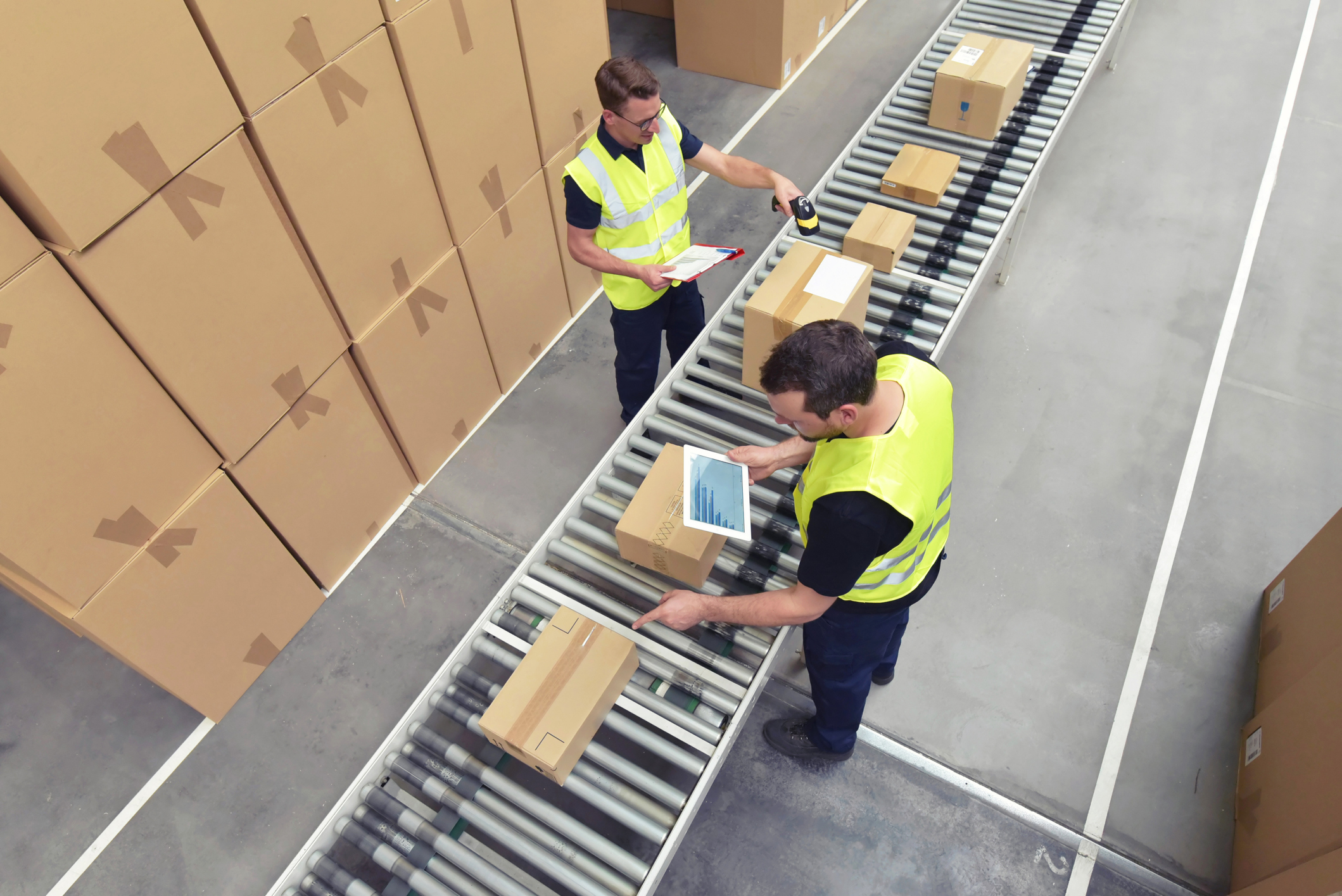 Worker in a warehouse in the logistics sector processing packages on the assembly line - transport and processing of orders in trade